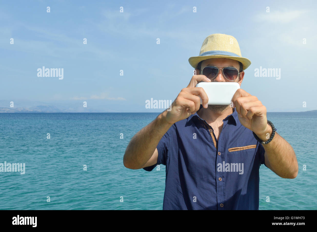 L'homme à prendre des photos avec son téléphone cellulaire à la mer Banque D'Images