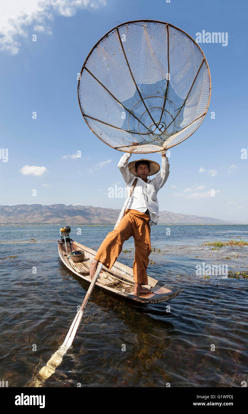 Sur le lac Inle, un pêcheur son bateau à rames avec une jambe sur un mouvement acrobatique (Myanmar) Pêcheur sur le lac inlé (Birmanie) Banque D'Images
