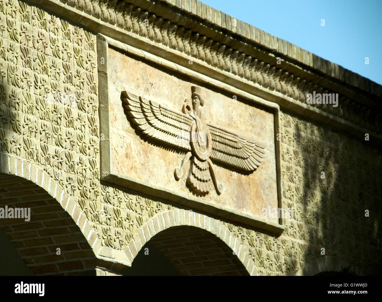Un trait distinctif de l'emblème ailé décore un mur du temple du feu à Yadz Banque D'Images