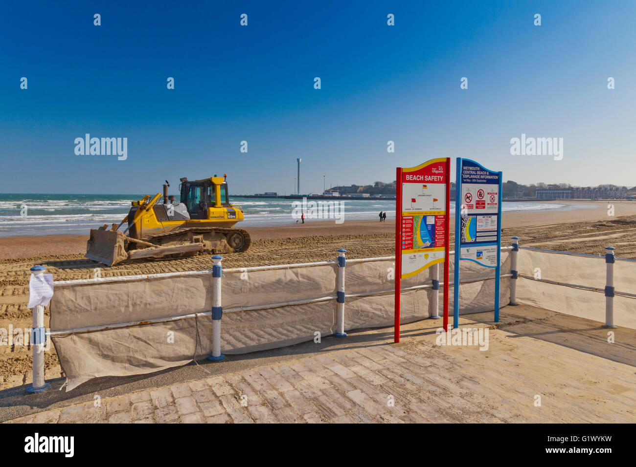 Un bulldozer à niveler le nouveau sable ajouté à la plage pour remplacer le sable enlevé par les tempêtes d'hiver à Weymouth, Dorset, Angleterre Banque D'Images