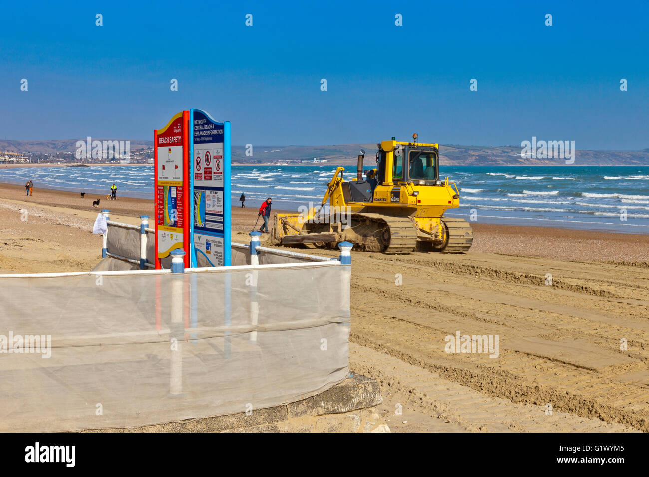Un bulldozer à niveler le nouveau sable ajouté à la plage pour remplacer le sable enlevé par les tempêtes d'hiver à Weymouth, Dorset, Angleterre Banque D'Images
