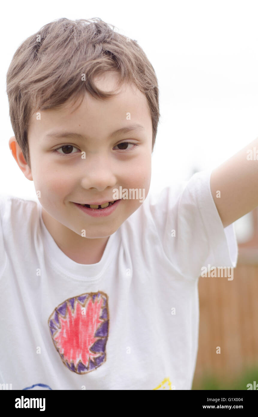 Un jeune garçon souriant à la caméra. Banque D'Images