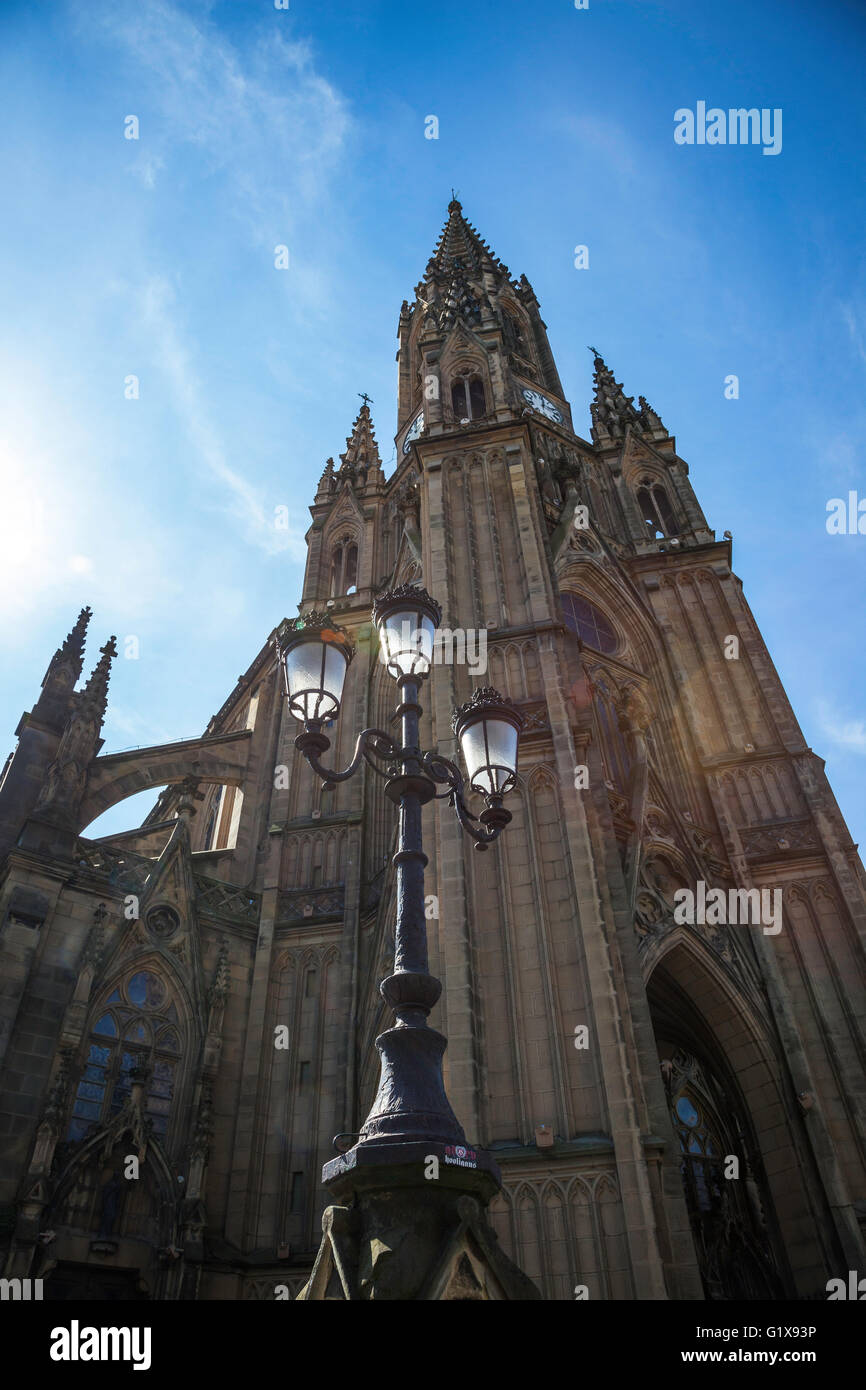 Triple lampe rétro-éclairée avec tour d'horloge de la cathédrale de Buen Pastor, San Sebastian, Espagne dans le fond contre un ciel bleu Banque D'Images