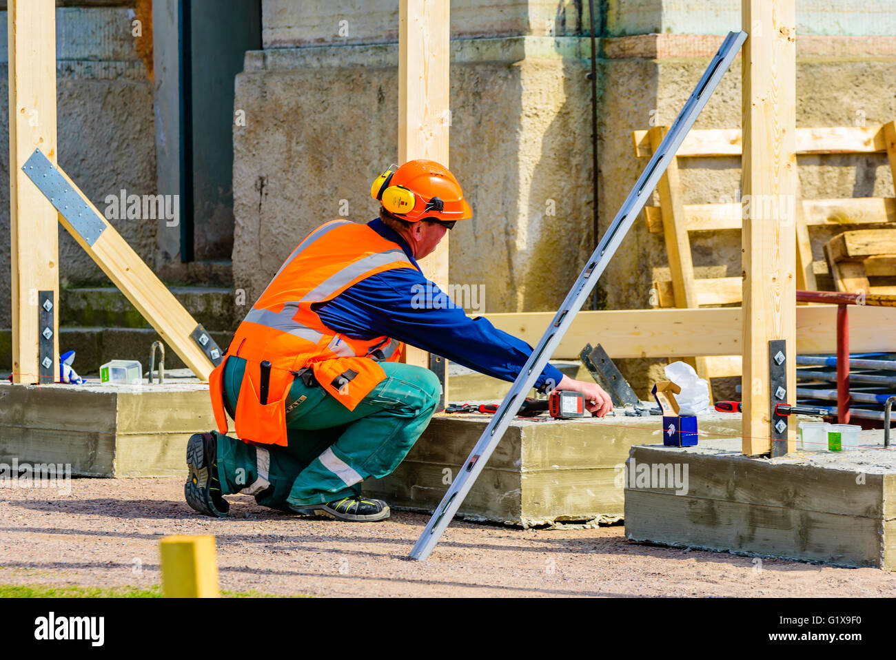 Karlskrona, Suède - mai 3, 2016 : un mâle de chantier la construction d'une clôture en bois à un site à l'extérieur d'une église à la place de la ville. Banque D'Images