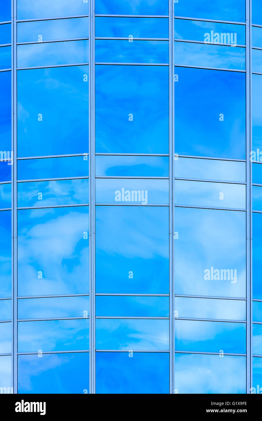 Détail de façade en verre de haute taille. Ciel avec nuages blancs se reflètent dans la surface du verre. Banque D'Images