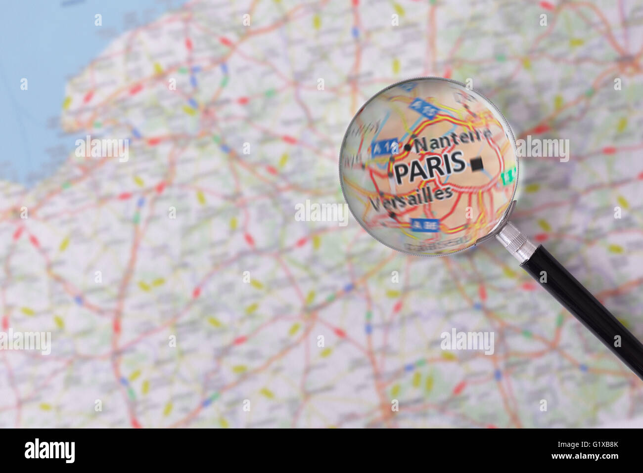 Plan de Paris consulté à l'aide d'une loupe en surbrillance le nom de la ville Banque D'Images