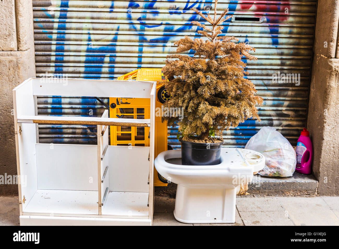 Corbeille de la rue où se dresse un arbre de Noël à l'intérieur d'une cuvette des toilettes dans la vieille ville de Barcelone Banque D'Images