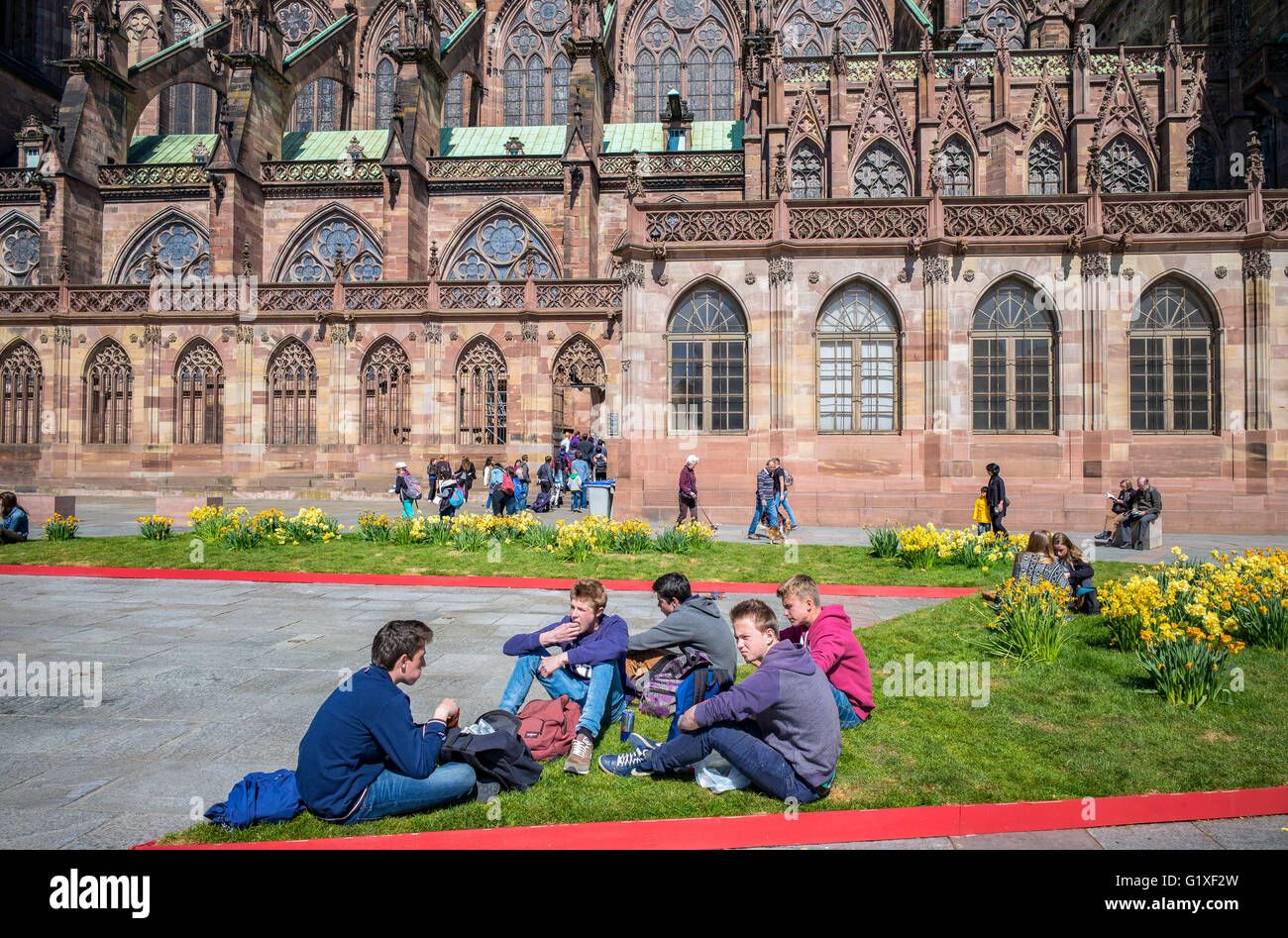 Les adolescents se détendre, Place du Château et la place Notre-Dame cathédrale gothique du 14e siècle, Strasbourg, Alsace, France Banque D'Images