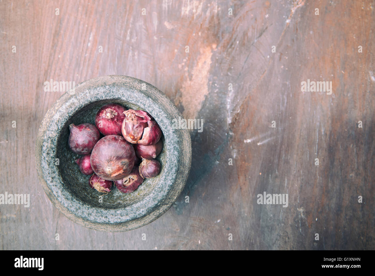 L'oignon rouge et mortier de pierre sur l'ancienne en bois. Banque D'Images