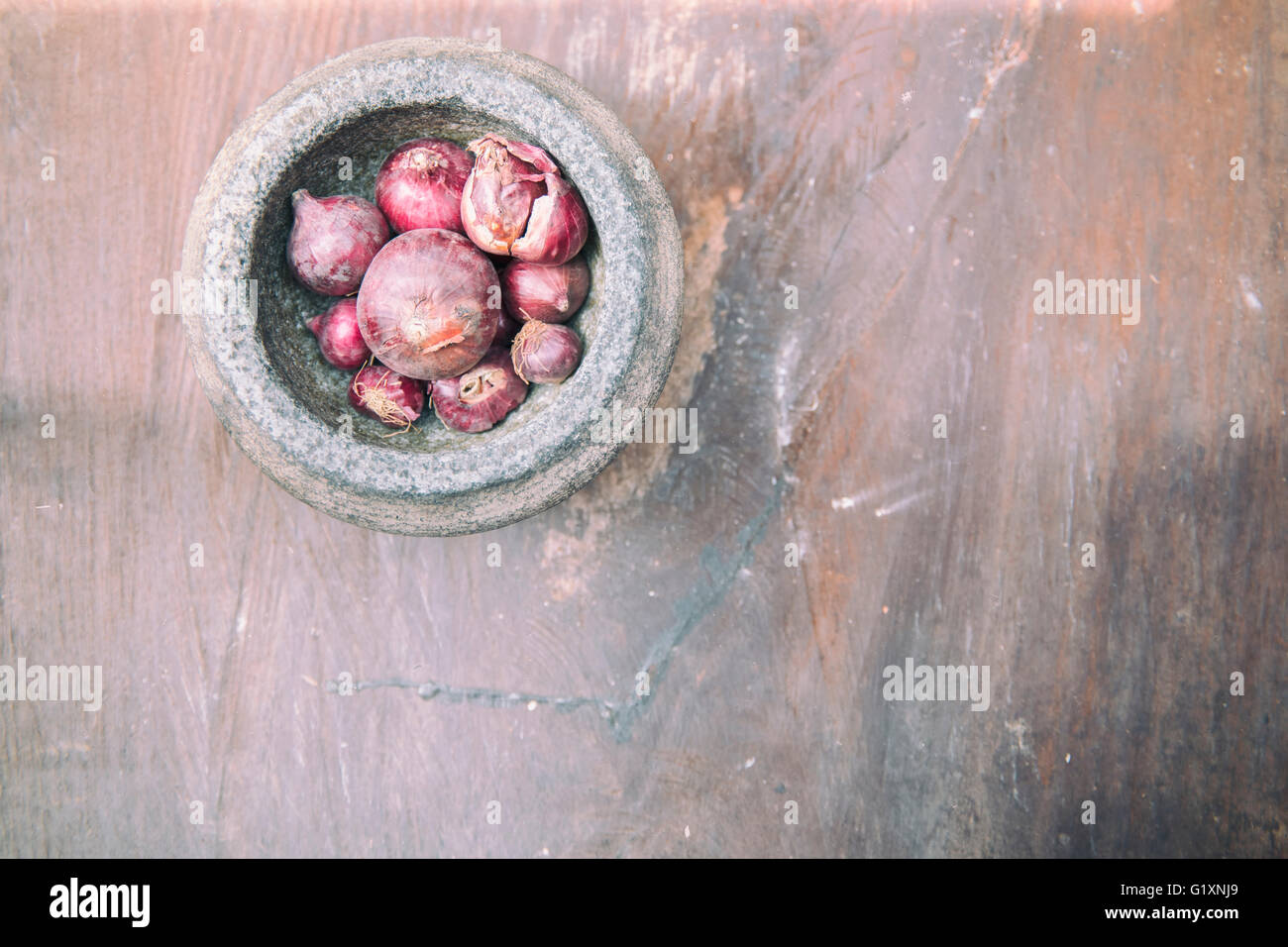 L'oignon rouge et mortier de pierre sur l'ancienne en bois. Banque D'Images