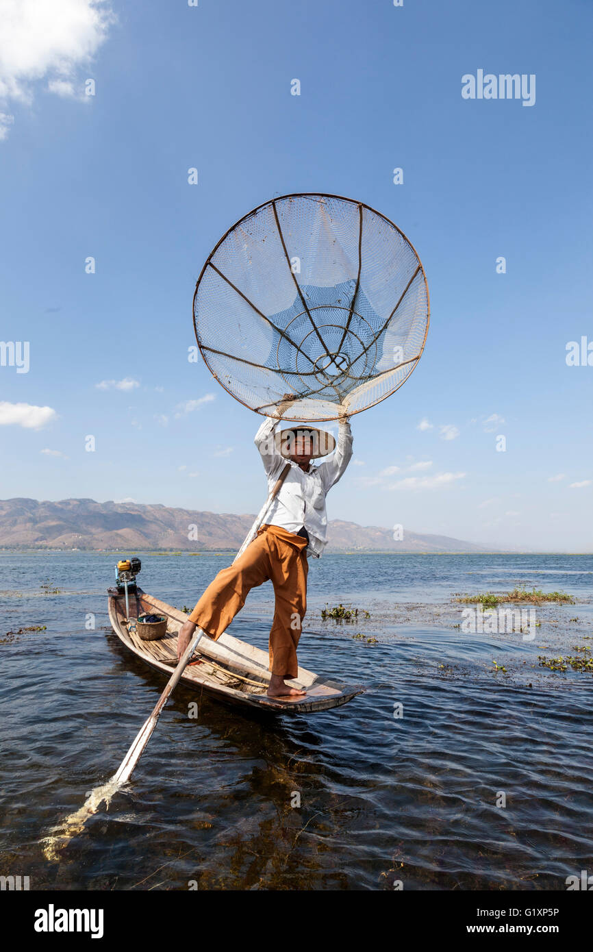 Sur le lac Inle, un pêcheur son bateau à rames avec une jambe sur un mouvement acrobatique (Myanmar) Pêcheur sur le lac inlé (Birmanie) Banque D'Images