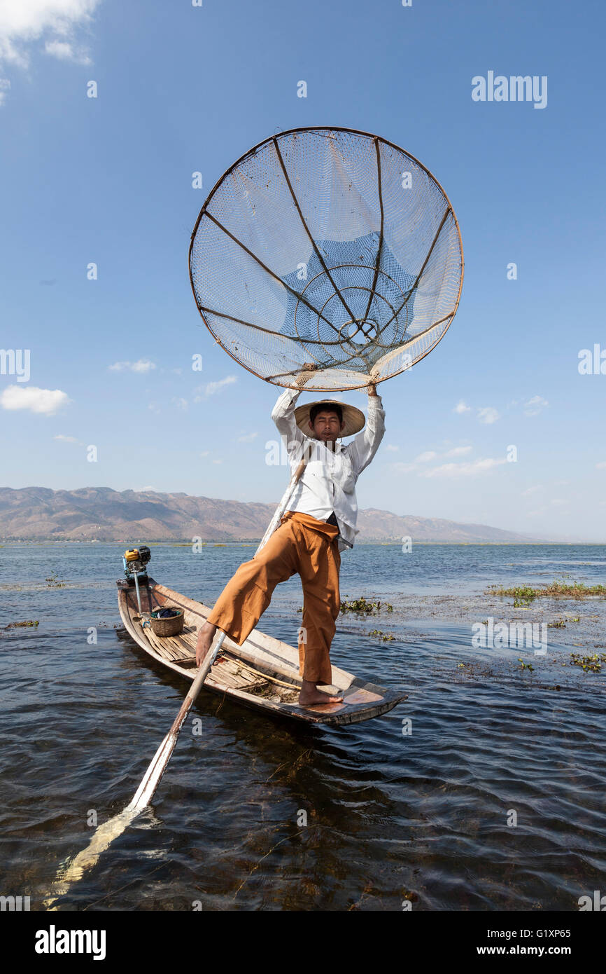 Sur le lac Inle, un pêcheur son bateau à rames avec une jambe sur un mouvement acrobatique (Myanmar) Pêcheur sur le lac inlé (Birmanie) Banque D'Images