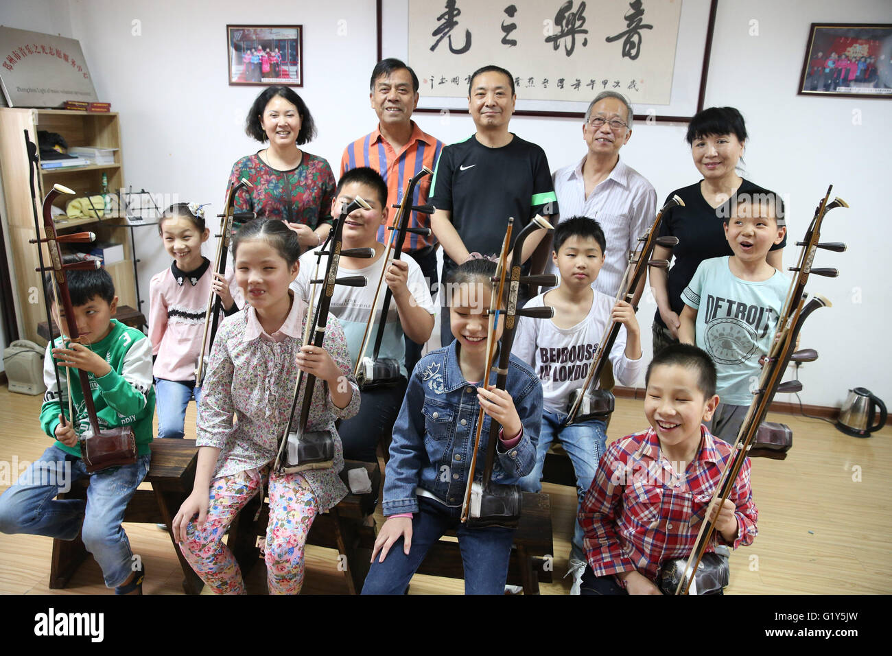 Zhengzhou, Chine. 20 mai, 2016. Les bénévoles (arrière) d'un organisme sans but lucratif Organisme de formation instrumentale pour les enfants handicapés posent pour une photo de groupe avec leurs élèves à Zhengzhou, capitale de la Chine, le 20 mai 2016. L'organisation fondée par Li Chaoyi en 2014 a plus de 10 bénévoles par maintenant, qui ont été l'enseignement plus de 50 enfants aveugles sur les instruments de musique comme l'Erhu. © Zhao Peng/Xinhua/Alamy Live News Banque D'Images
