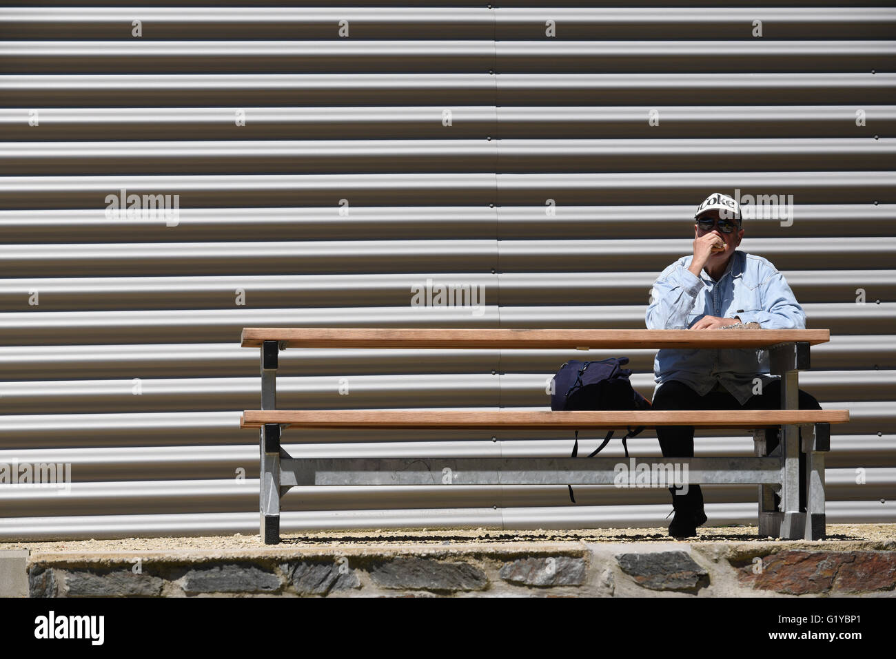 Que l'homme bénéficie d'un repas sur banc de pique-nique Banque D'Images