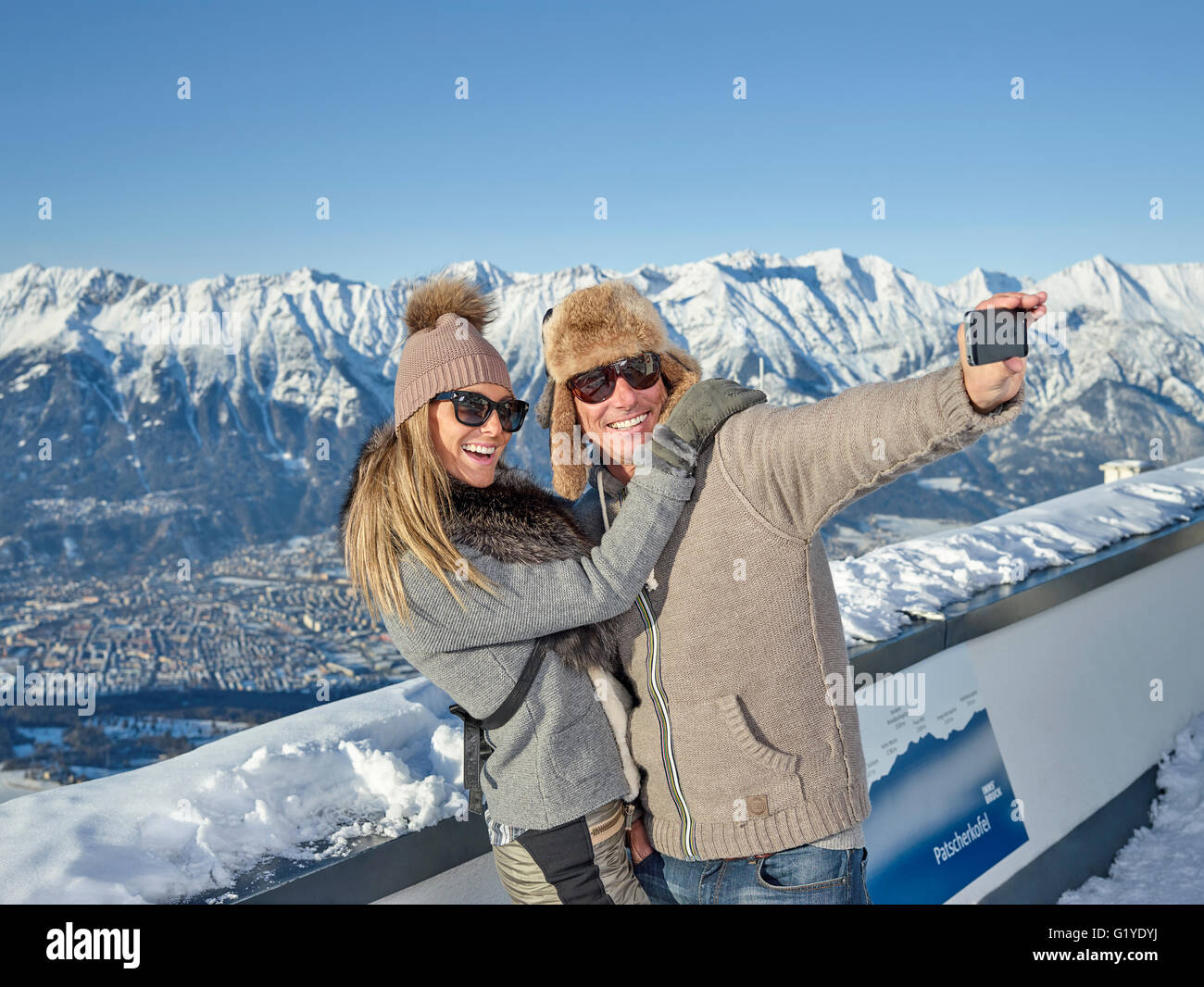 Couple photographing themselves, faisant un en face de selfies paysages de montagne, Patscherkofel, Patsch, chaîne de l'Inntal, Innsbruck, Tyrol Banque D'Images