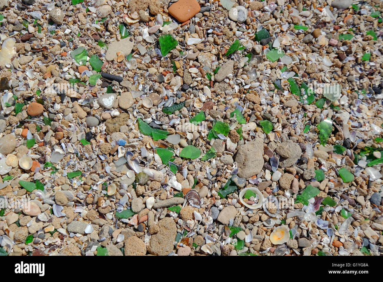 De grandes quantités de verre cassé entre les galets sur une plage sur la côte marocaine Banque D'Images