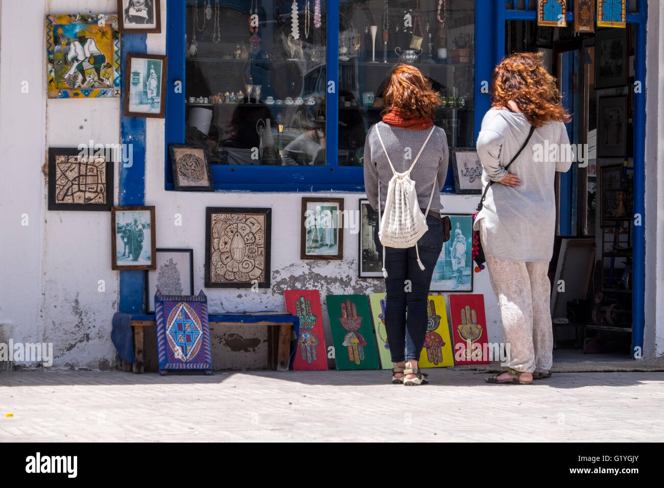 Deux femmes les touristes à la recherche de la fenêtre d'un magasin de souvenirs à Essaouira, Maroc Banque D'Images