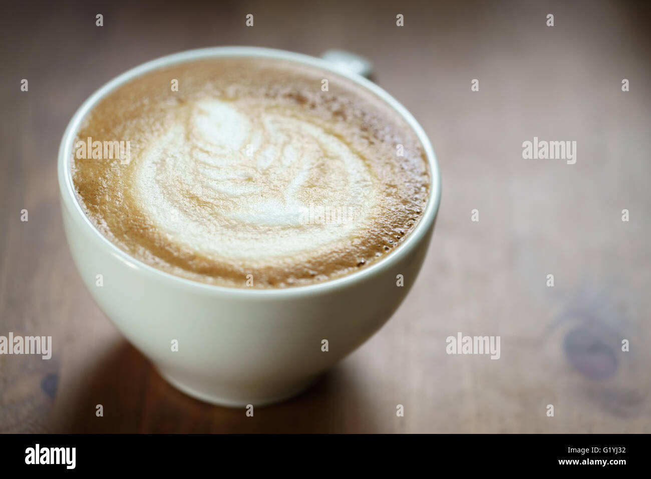 Douce chaude tasse de café avec latte art sur table en bois Banque D'Images