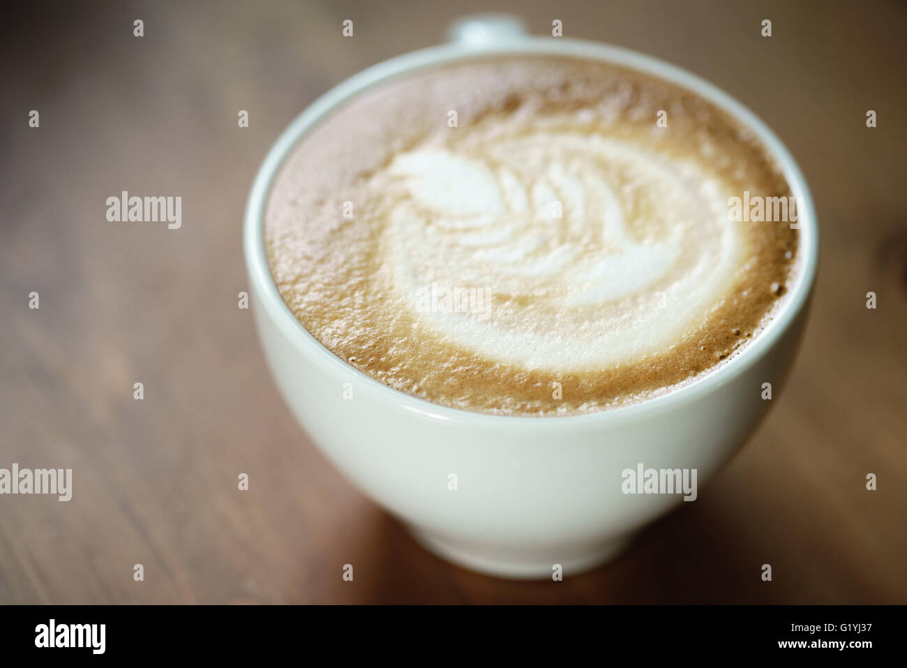 Douce chaude tasse de café avec latte art sur table en bois Banque D'Images