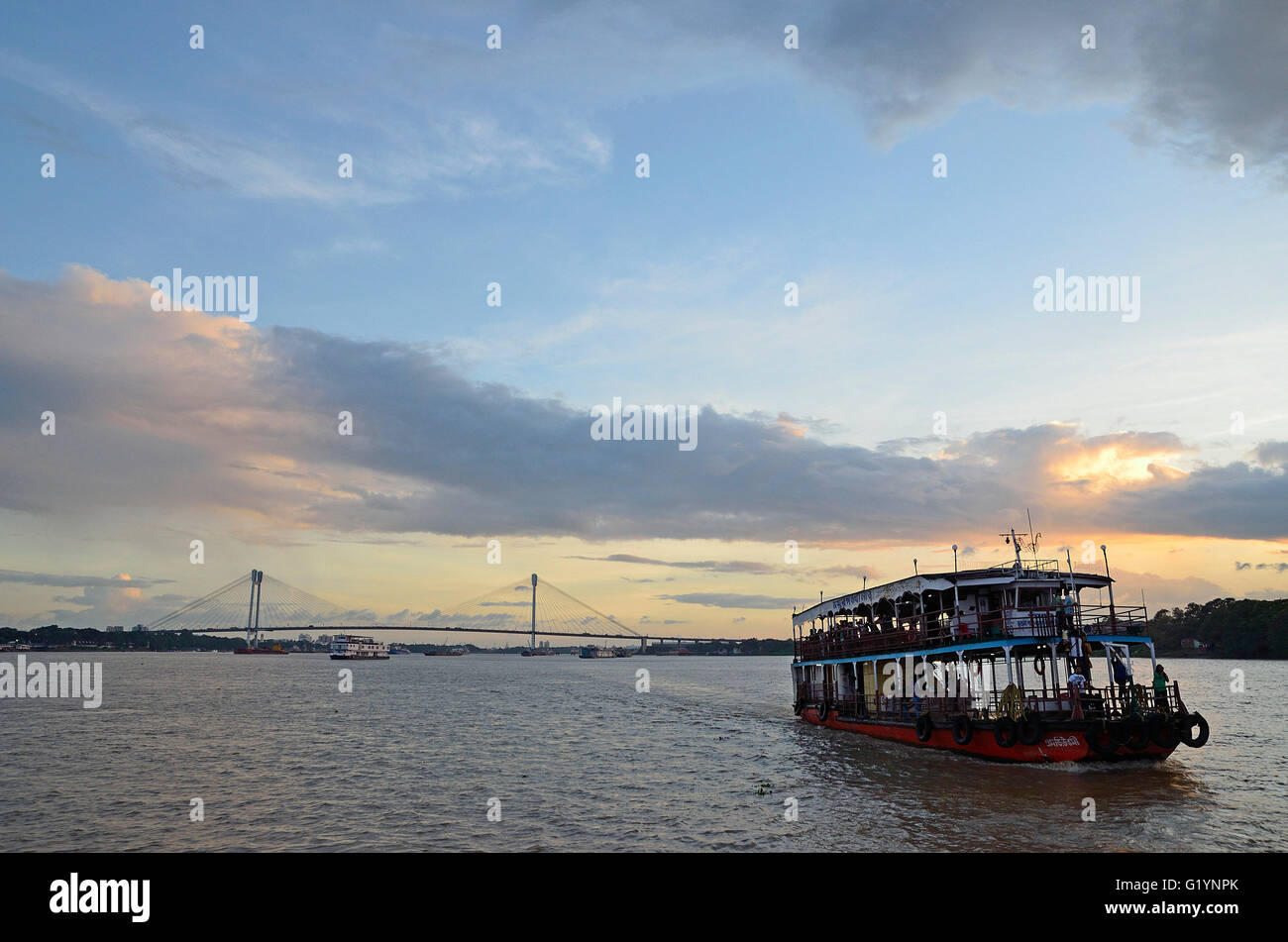 Des bateaux de transport sur le fleuve Hooghly sur un coucher du soleil la mousson, Kolkata, West Bengal, India Banque D'Images