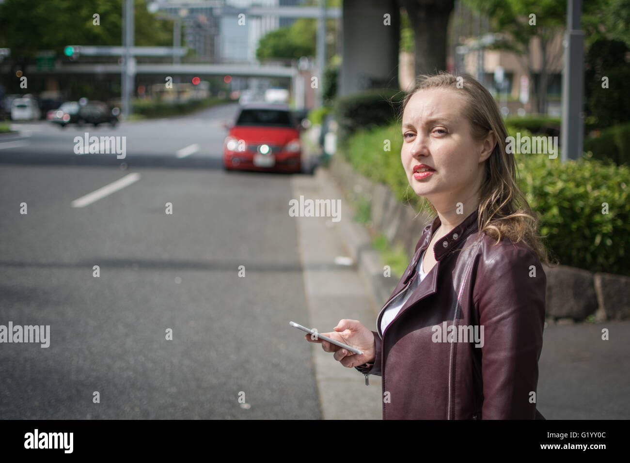 Jeune femme blanche en attente de taxi ou ascenseur Banque D'Images