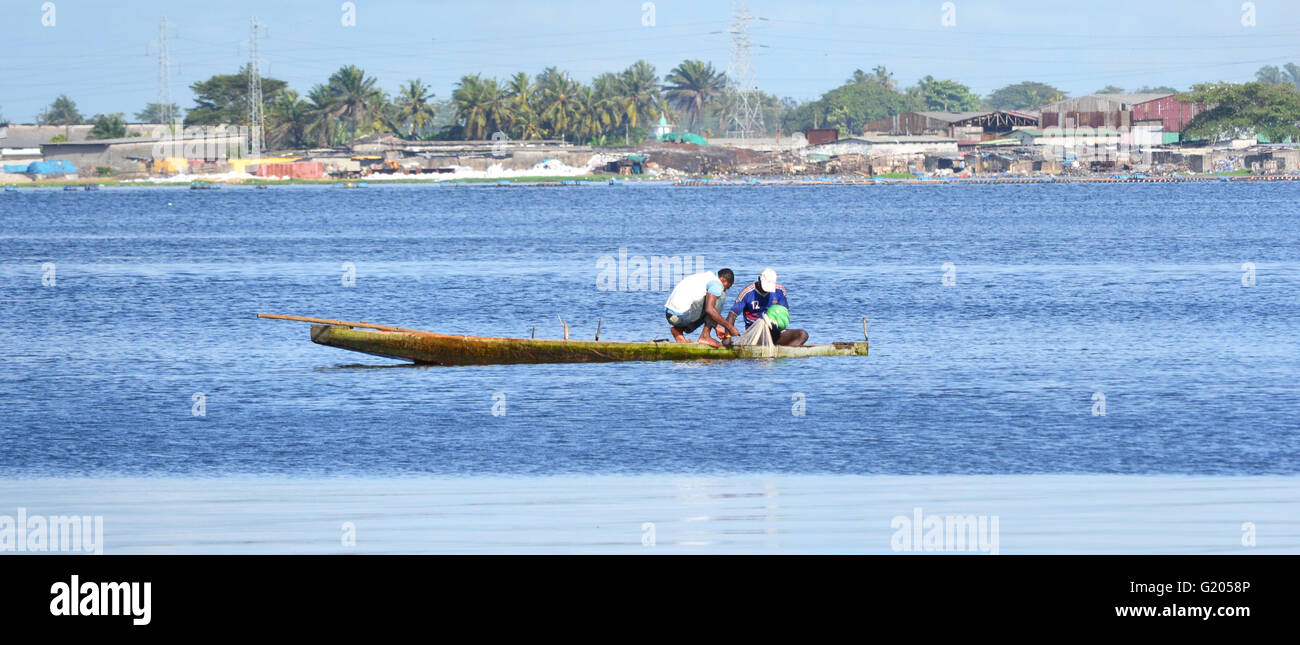 Deux hommes avec un filet de pêche dans la lagune d'Abidjan, Côte d'Ivoire Banque D'Images