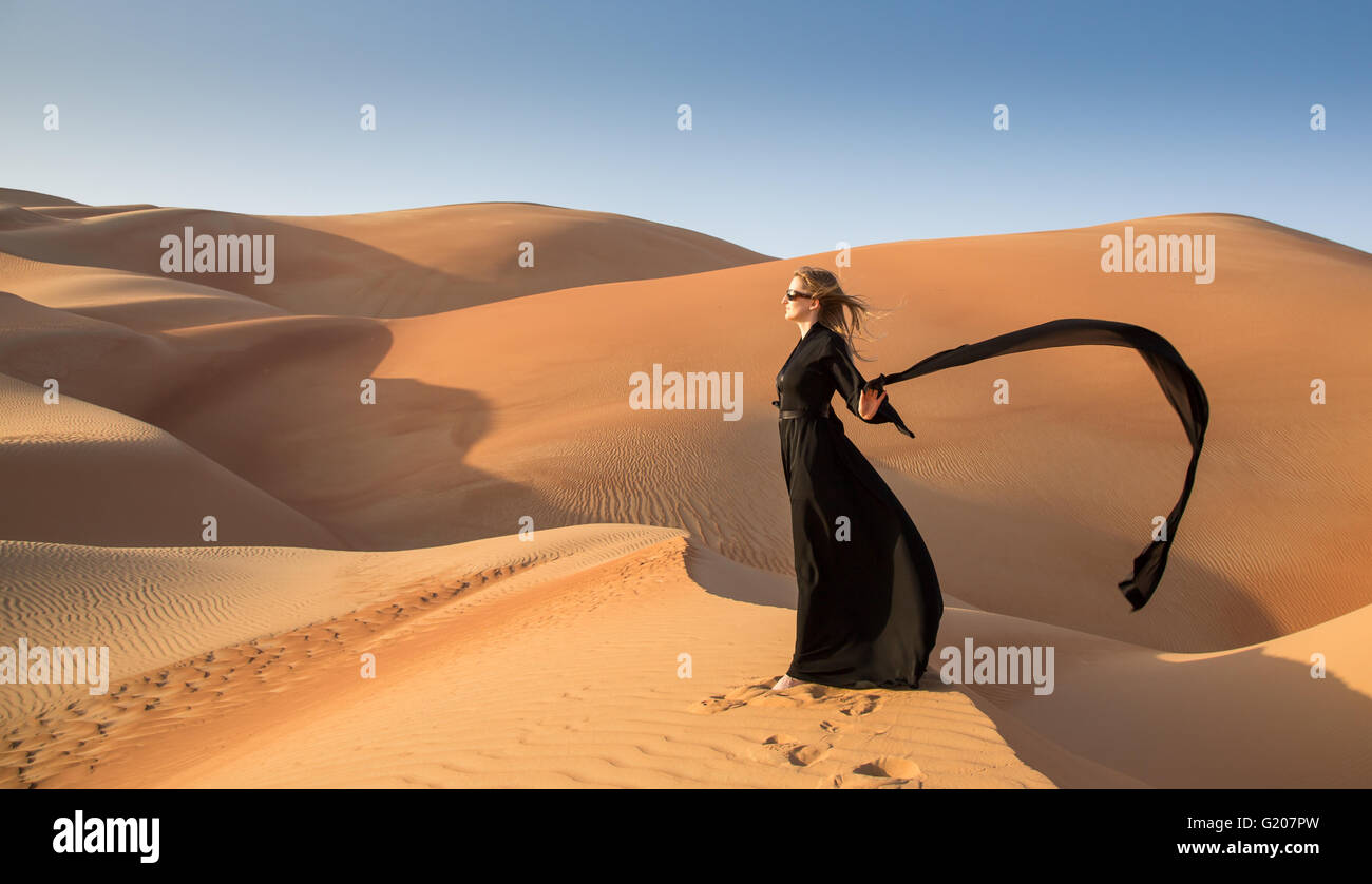 Une femme en abaya en dunes de sable dans le désert de Liwa, Aby Dhabi, EAU Banque D'Images