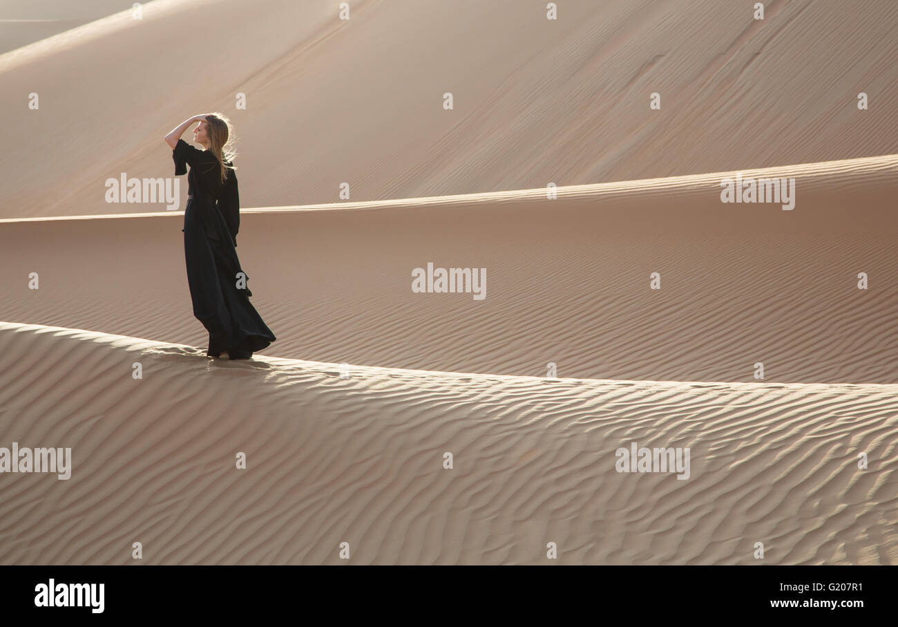 Une femme en abaya en dunes de sable dans le désert de Liwa, Aby Dhabi, EAU Banque D'Images