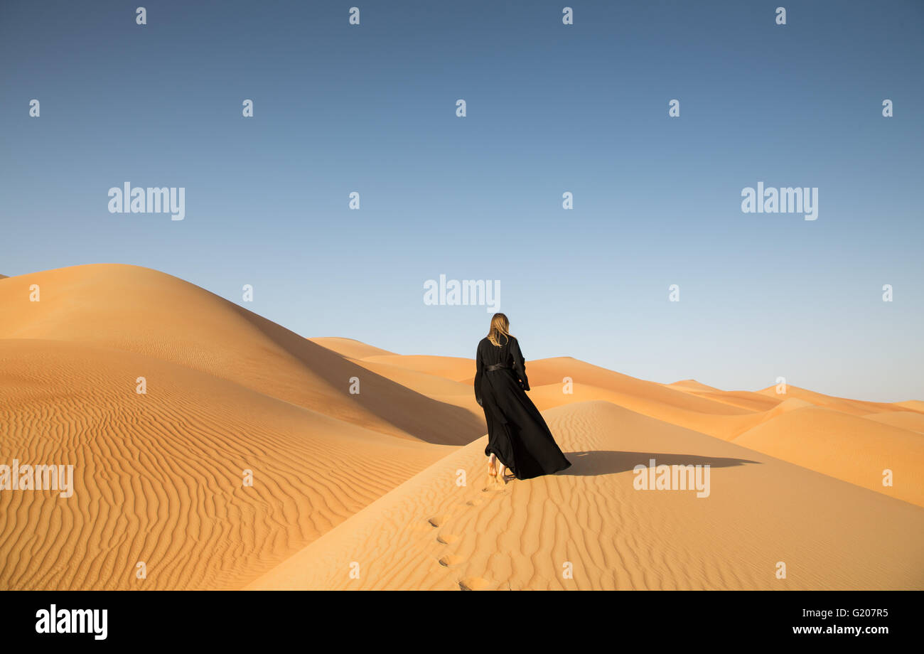 Une femme en abaya en dunes de sable dans le désert de Liwa, Aby Dhabi, EAU Banque D'Images