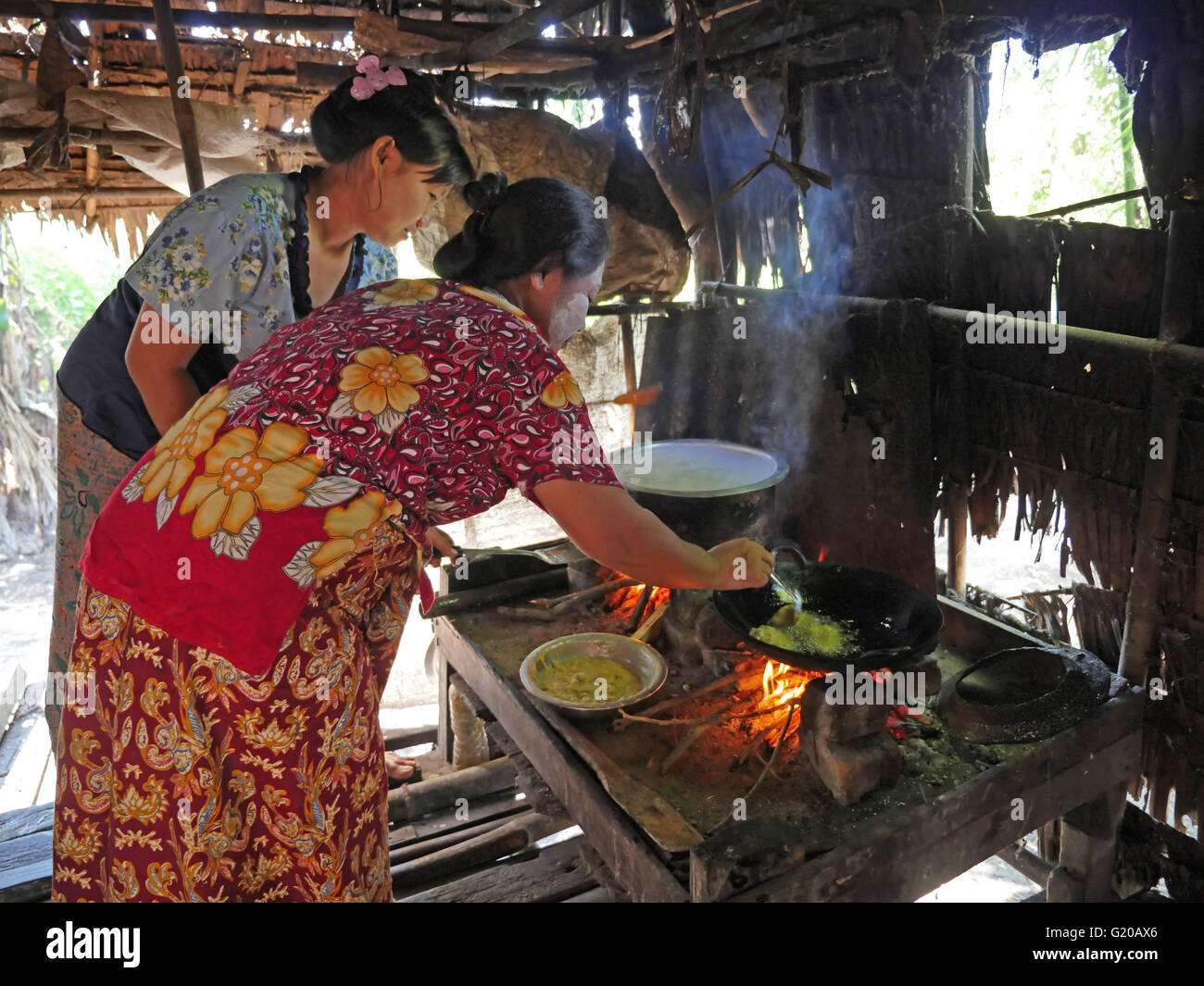 Visiter le Myanmar Kyaung Thayer, un petit village dans un bras de l'Irriwaddy, en face de Yangon. Site du projet de Philippine jeter commissaire Emily Valdez. Les femmes la cuisson à feu ouvert. Banque D'Images