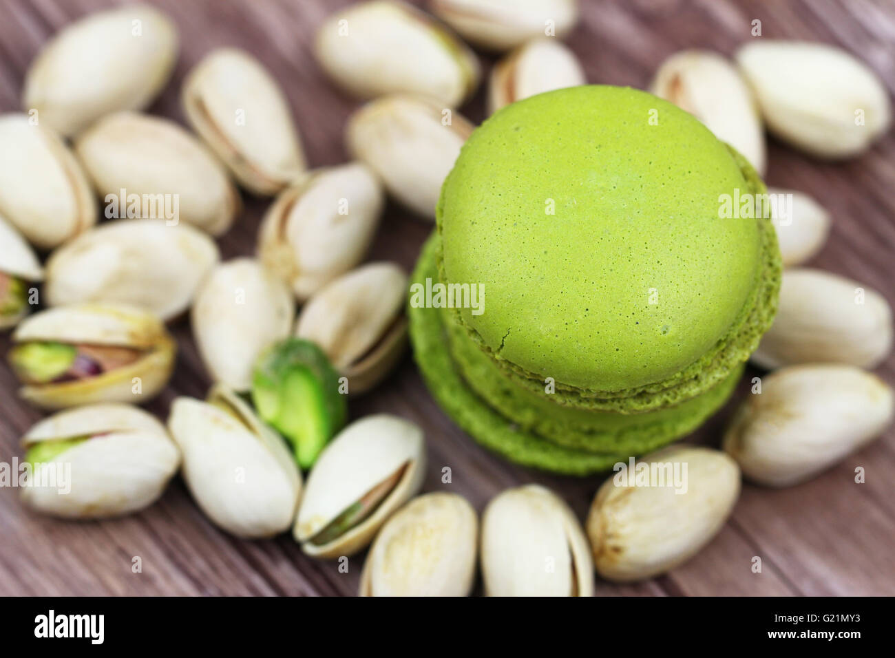 Macarons pistache croquants empilés sur des pistaches, Close up Banque D'Images