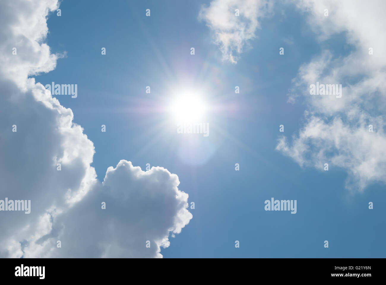 Soleil et nuages contre un ciel bleu. Banque D'Images