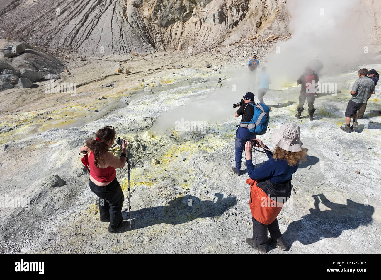 Photographes prend une photo de paysage volcanique et active, l'éjection de fumerolles de soufre et de vapeur du gaz en cratère de volcan actif Banque D'Images