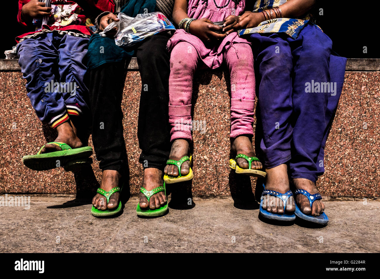 Les enfants sans-abri assis sur un mur à New Delhi, Inde, Banque D'Images