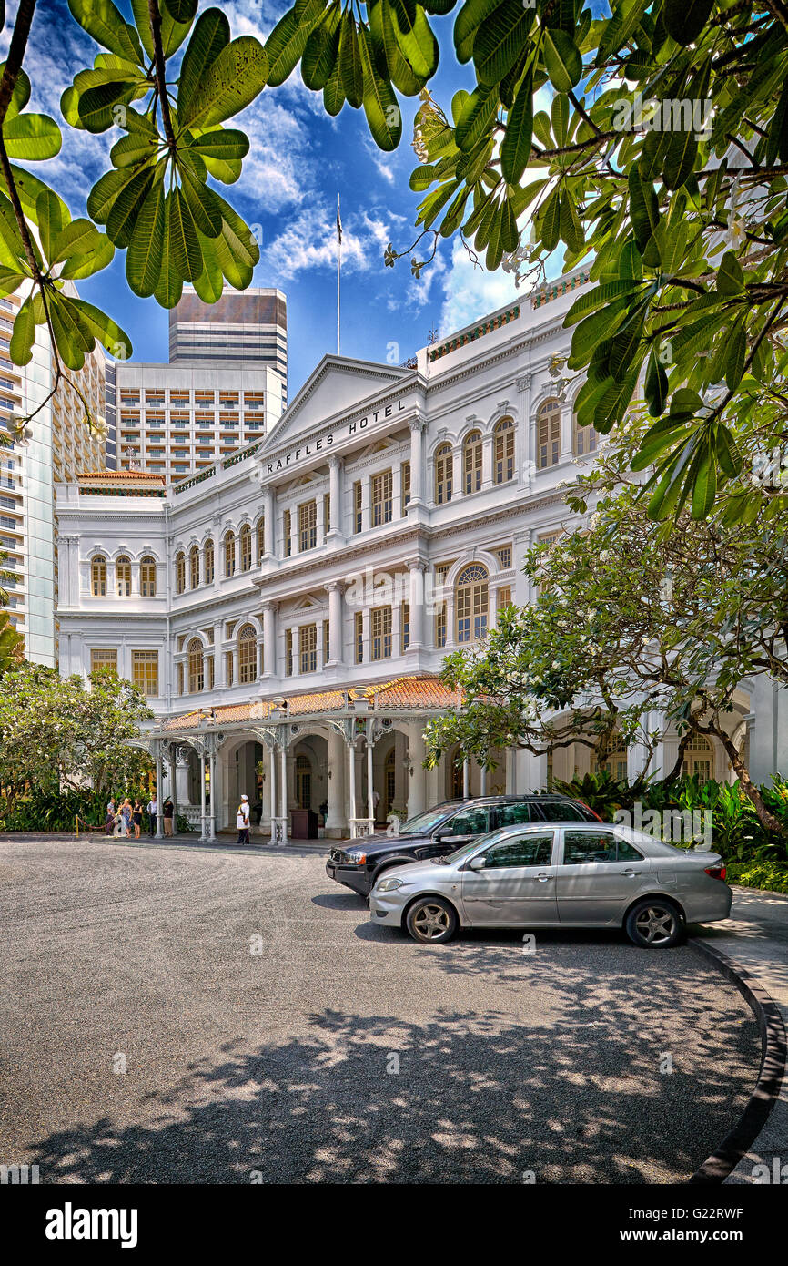 Le lecteur moyen et l'entrée principale de l'Hôtel Raffles à Singapour le 11 juillet 2012. Banque D'Images