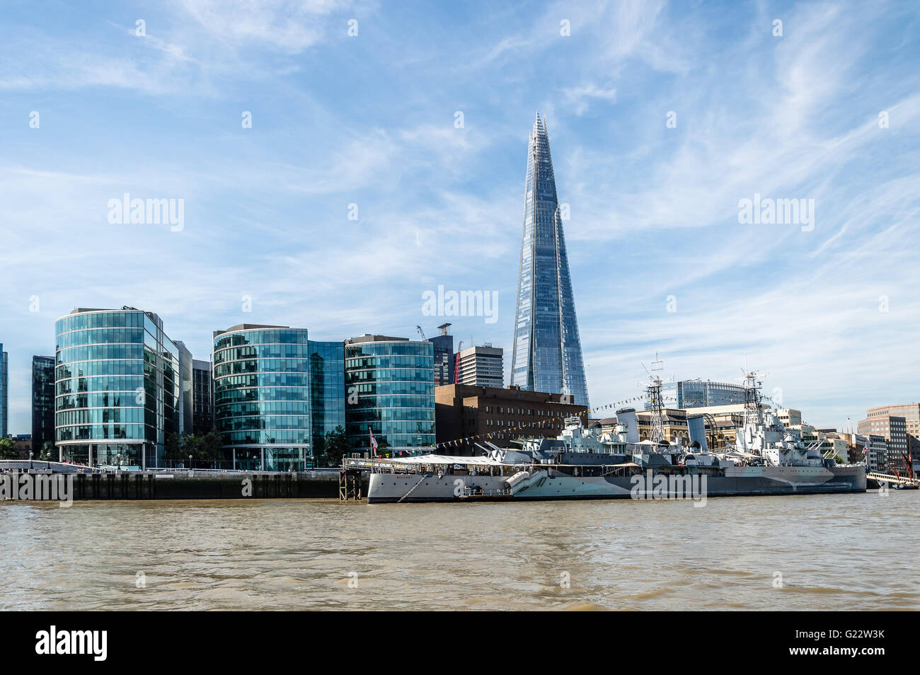 Au bord de l'HMS Belfast Londres avec navire et les édifices à bureaux d'une journée ensoleillée avec ciel bleu Banque D'Images