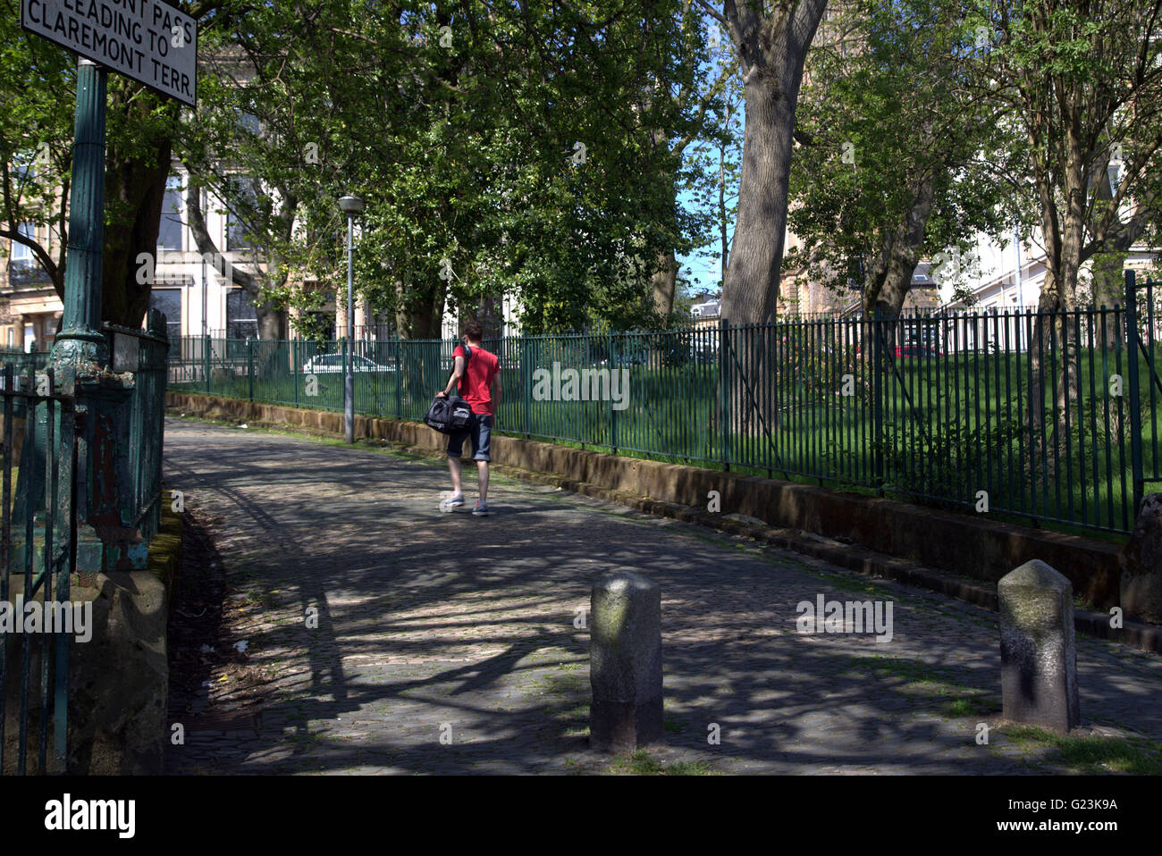 Jeune homme marchant dans la ville pittoresque de Claremont col,Park Circus, Glasgow, Ecosse, Royaume-Uni. Banque D'Images