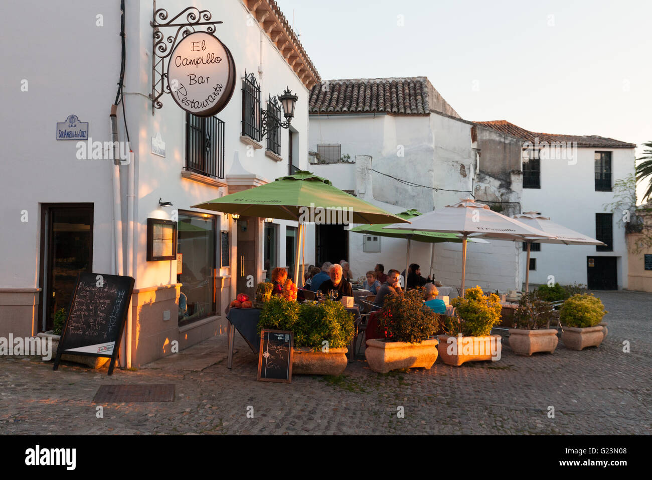 Des gens assis manger dans un restaurant le soir, Ronda, Andalousie Espagne Banque D'Images
