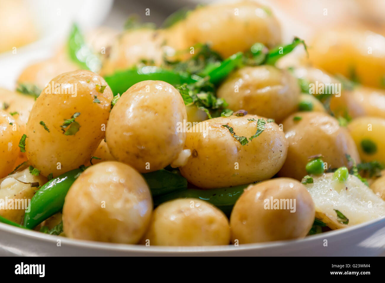 Hot buttered bébé pommes de terre nouvelles dans les herbes Banque D'Images