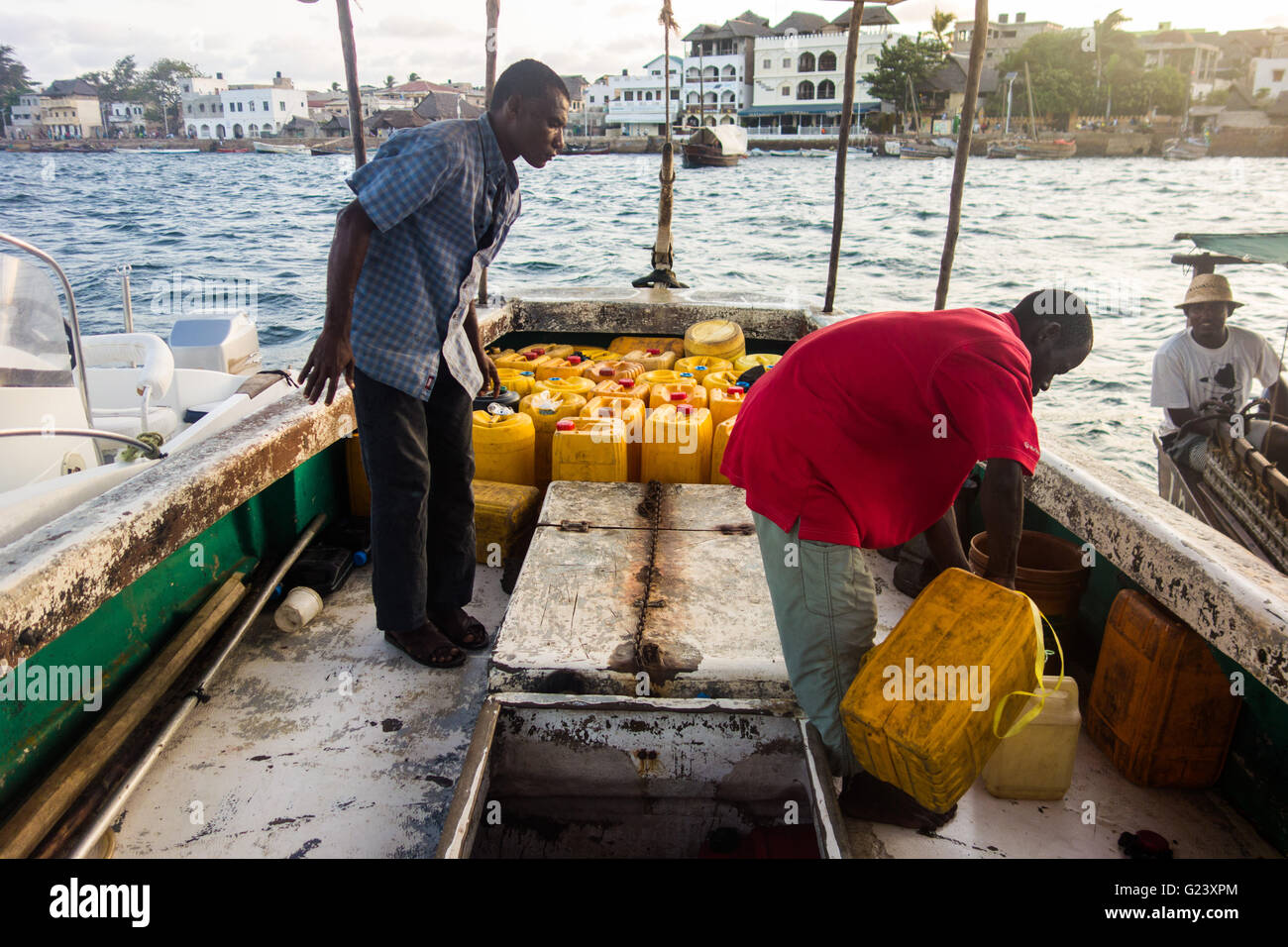 Un homme prend un bateau de ravitaillement en carburant à partir de à Lamu, Kenya Banque D'Images