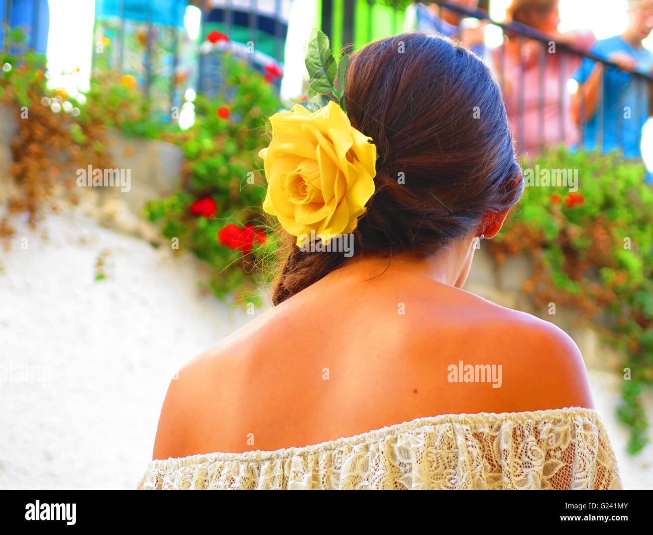 Jeune femme espagnole avec fleur jaune dans les cheveux à l'échelle locale à Alora fiesta, Andalousie Banque D'Images