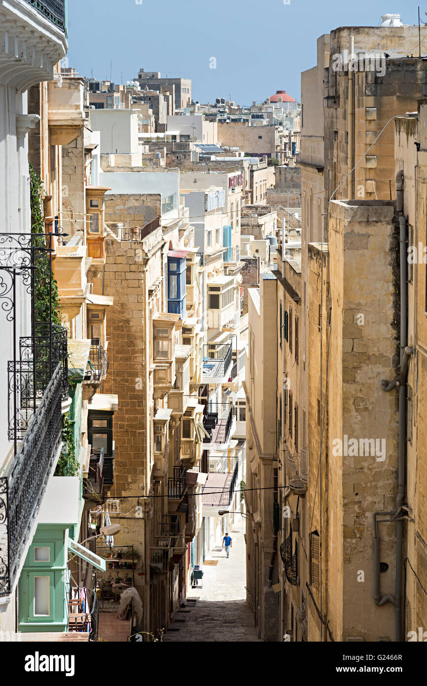 Personne dans la rue étroite avec de grands bâtiments, La Valette, Malte Banque D'Images