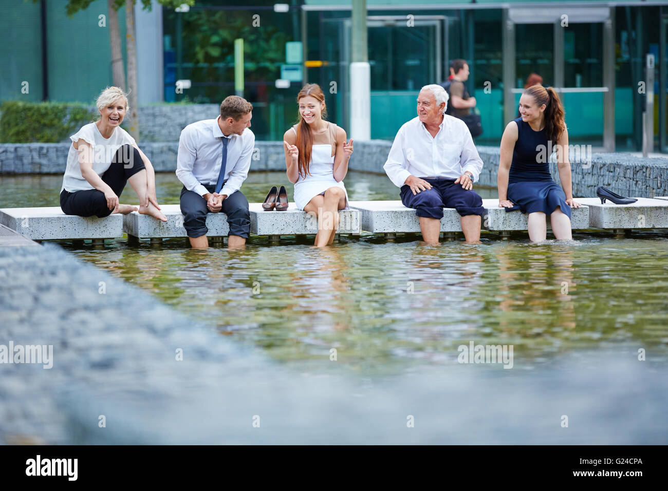 Happy business people talking in l'été avec leurs pieds dans l'eau Banque D'Images