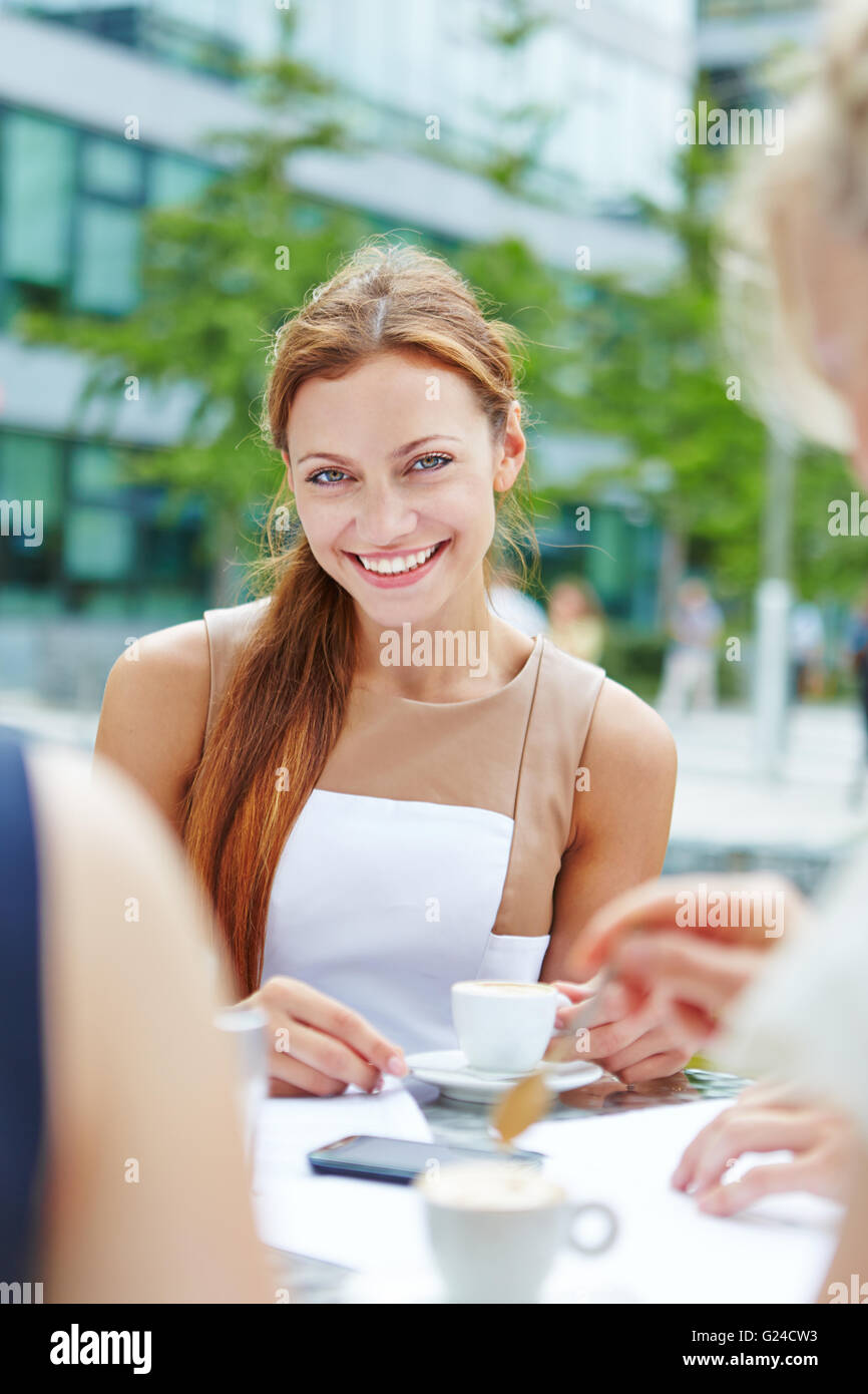 Young smiling woman drinking a cup of espresso dans un café Banque D'Images
