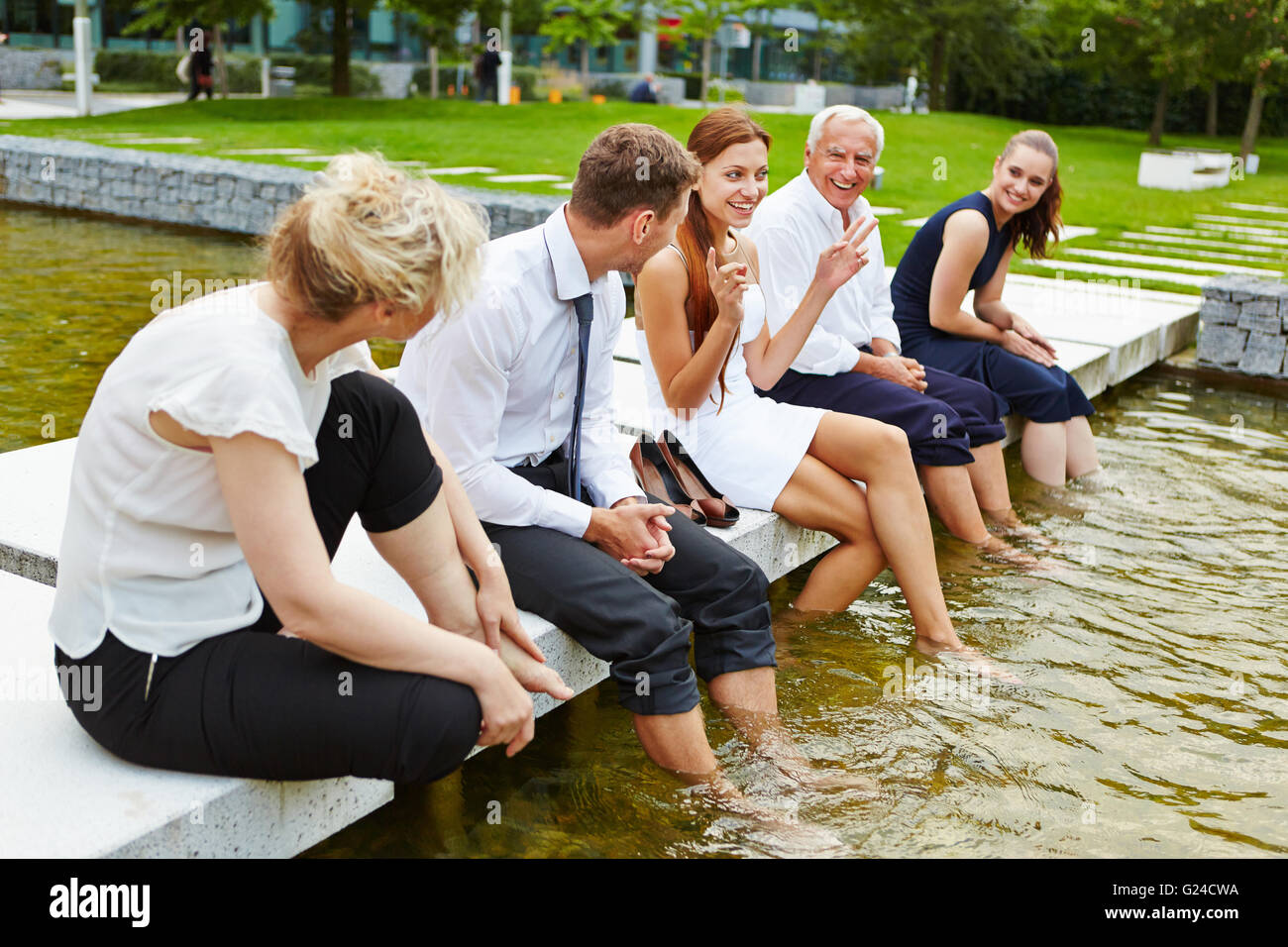 En été de l'équipe Entreprises leurs pieds dans l'eau de refroidissement au cours d'une réunion Banque D'Images