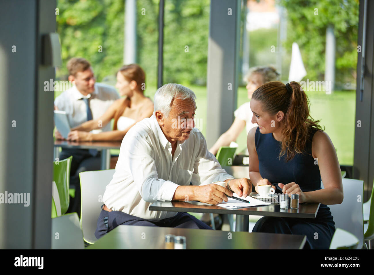 Femme d'affaires et avocat senior assis dans une réunion à une table Banque D'Images