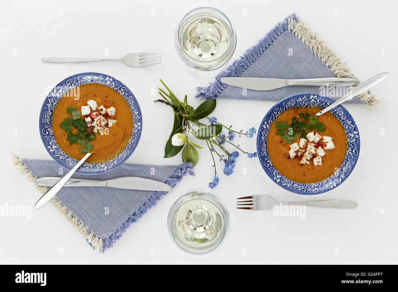 Assiettes et verres, dîner romantique pour deux. L'atmosphère accueillante tableau blanc propre. Vue d'en haut. Soupe Orange Banque D'Images