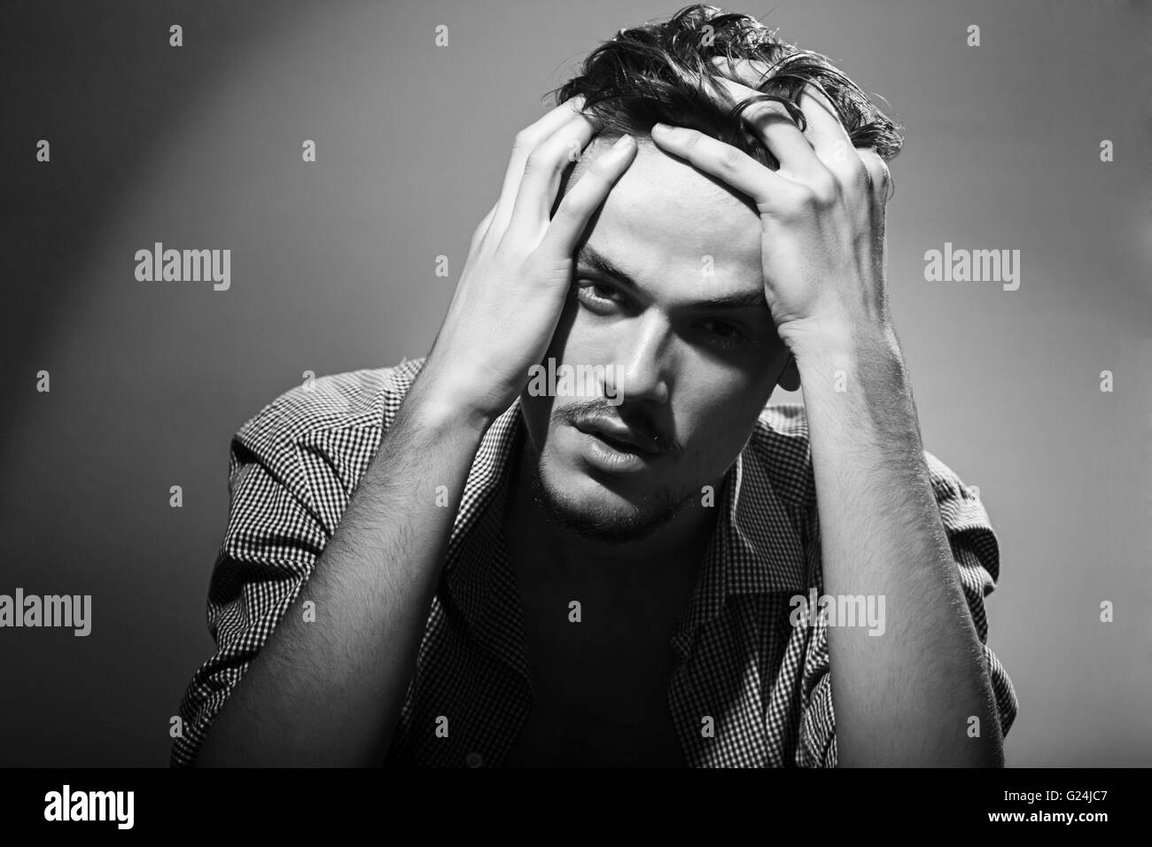 Portrait noir et blanc d'un jeune homme en studio Banque D'Images