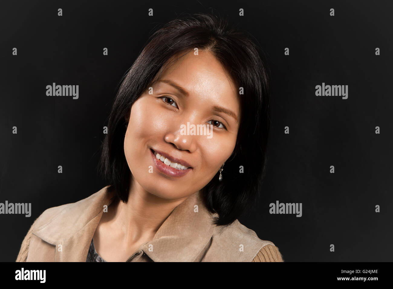 Jolie femme asiatique avec attitude positive déclinée pour l'appareil photo. Banque D'Images
