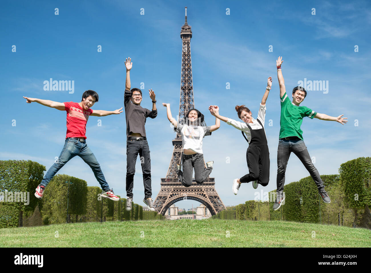 L'été, vacances, congés, les gens heureux concept - groupe d'amis de sauter sur le parc près de la tour Eiffel à Paris, France Banque D'Images